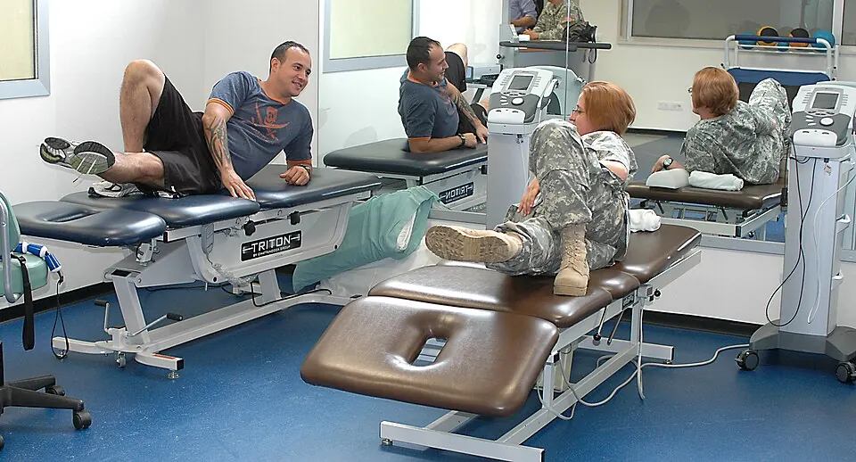 Physical therapist demonstrating a leg-strengthening recovery exercise